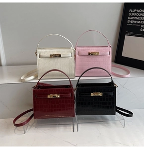 Detail of four crocodile embossed Kelly bags in white, pink, burgundy, and black finishes