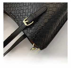 Close-up of golden hardware buckle and woven texture on a black crossbody bag
