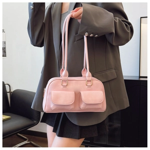Detail of pink PU leather Boston bag featuring two cargo-style front pockets and gold hardware