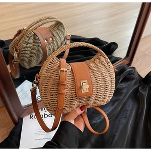 Macro detail of hand-woven straw texture and leather trim with metal twist lock closure