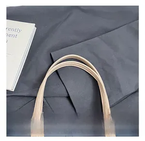 Detail of sturdy beige faux leather handle with fine parallel stitching on stylish handbag