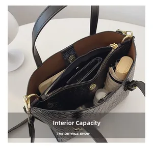 Detail view of the black textured handbag showing internal capacity and brown lining