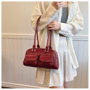 Detail of a retro burgundy faux leather tote bag with dual front pockets and shoulder straps