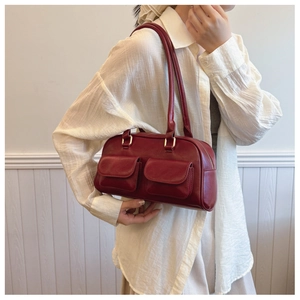 Detail of red vintage matte leather tote bag with functional pockets and gold buckles