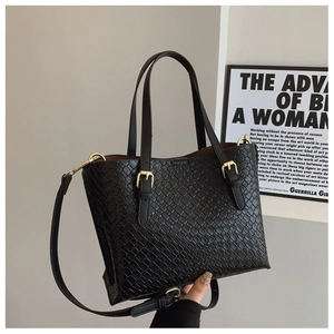 Detail of black woven PU leather tote bag with gold buckle and adjustable strap