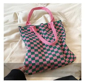 Détail d'un grand sac cabas en tricot avec motif damier rose et vert pour femme
