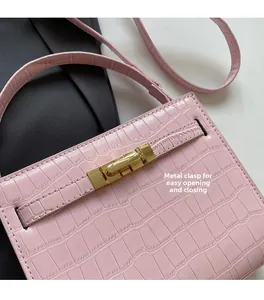 Close-up of pink crocodile-embossed leather with a secure golden twist lock buckle