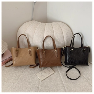 Detailed close-up of stylish woven texture underarm bags in black and brown finishes