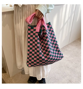 Détail d'un cabas en maille douce avec motif à damier rose et vert foncé contrasté