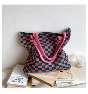 Gros plan du cabas en maille à damier rose et vert sur des livres avec un café