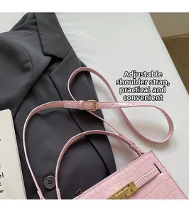 Detail of adjustable shoulder strap buckle on a pink crocodile pattern handbag