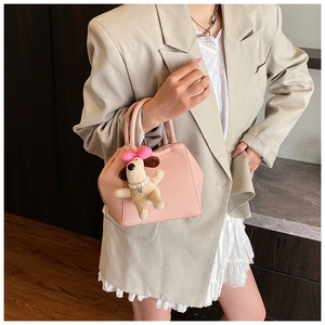 Pink textured leather bag detail with cute puppy plush charm and pearl necklace detail