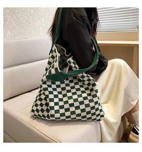Détail de la texture tricotée du cabas à damier vert avec bandoulière tissée robuste