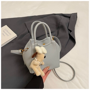 Detail of light blue lychee pattern leather bucket bag with cute plush doll charm