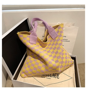 Détail du sac cabas en maille damier jaune et violet dans un coffret cadeau