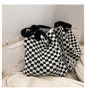 Détail du grand sac cabas en maille à damier montrant la texture douce du tissu