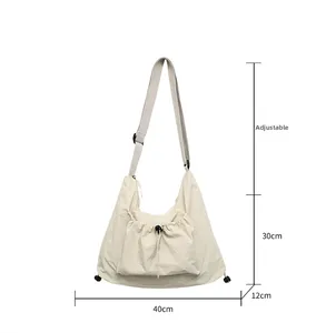Close-up of beige tote bag showing adjustable strap and front drawstring pocket details