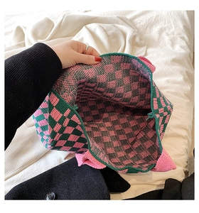 Détail du sac cabas tricoté à damier montrant la texture rose et verte et l'espace intérieur