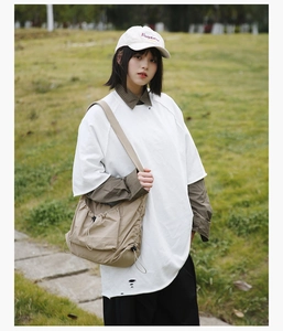 Outdoor look at khaki nylon drawstring crossbody bag styled with a white oversized t-shirt