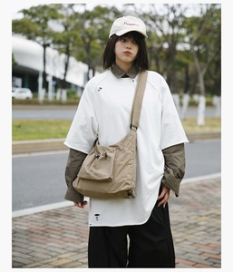 Outdoor street style shot of the khaki utility tote bag with a white oversized T-shirt