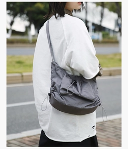 Detail of adjustable drawstring structure on grey nylon tote bag for women