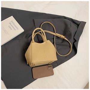 Detailed view of beige lychee texture leather handbag with adjustable strap and zip base