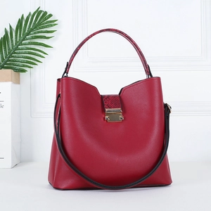 Detail of red PU leather handbag featuring exotic python texture handles and gold hardware