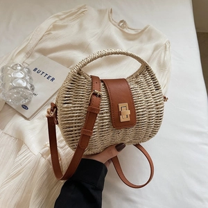 Minimalist straw crossbody bag with brown faux leather trim and golden twist lock closure