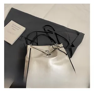 Detail of cream PU leather tote bag featuring contrast black trim and silver twist lock