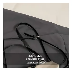 Close-up of adjustable black leather strap with silver metal buckle on a tote bag