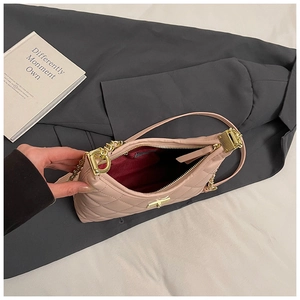 Détail du sac matelassé rose montrant la chaîne dorée et la doublure rouge interne