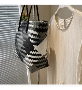 Macro detail of the woven texture and black handles on the large handmade tote bag