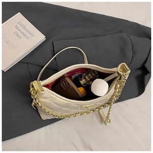 Détail du sac matelassé crème montrant la doublure bordeaux et la capacité pour maquillage