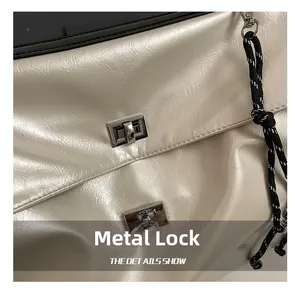 Detail of light beige leather texture with dual silver rectangle twist locks and braided strap