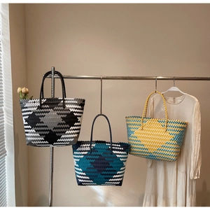 Detail of colorful geometric woven tote bags featuring reinforced double handles for summer