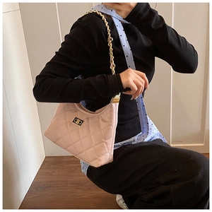 Détails de la texture en cuir rose matelassé et bandoulière chaîne dorée du sac à main