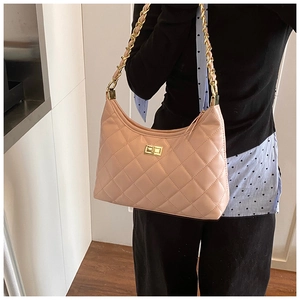 Détail du sac matelassé rose clair avec boucle dorée et bandoulière en chaîne dorée