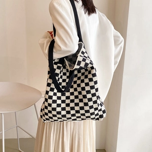 Grand sac cabas en maille à damier, texture souple, porté à l'épaule pour un style décontracté