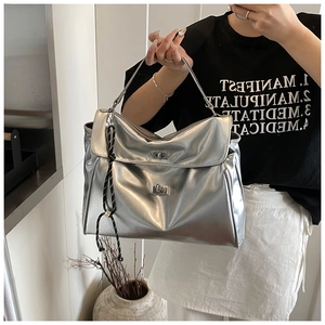 Detailed view of silver metallic tote bag with decorative cord and metal twist locks