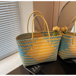 Close-up of handwoven tote bag with yellow and teal geometric weave texture