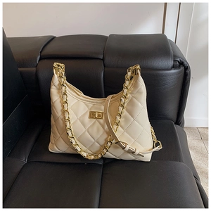 Détail du sac hobo matelassé crème avec fermoir rotatif doré et bandoulière chaîne