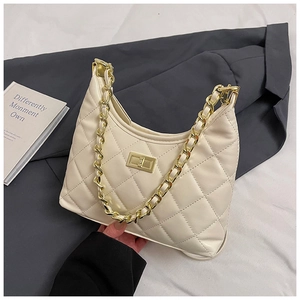 Détail d'un sac à main beige matelassé avec chaîne dorée et fermoir rotatif luxueux