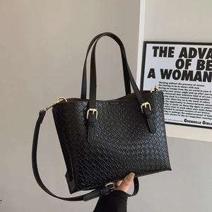 Fashionable black woven tote bag with gold buckles for women shown in hand