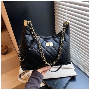 Détail du sac bandoulière matelassé noir avec chaîne dorée et fermoir rotatif