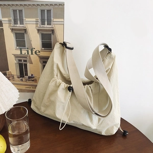 Minimalist cream shoulder tote bag with pleated design and wide adjustable strap