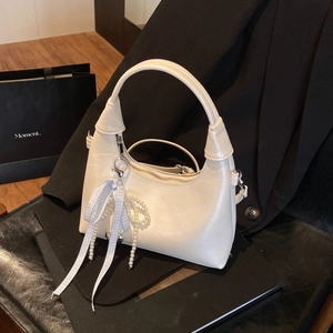 Détail du sac hobo blanc avec nœud à carreaux bleu clair et breloques en perles élégantes
