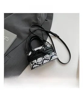 Close-up of black and white snakeskin pattern crossbody bag with silver hardware