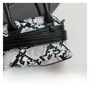 Close-up of premium black and white snakeskin texture on a luxury crossbody bag