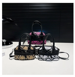 Three snakeskin pattern mini bowling bags in magenta, brown, and monochrome tones