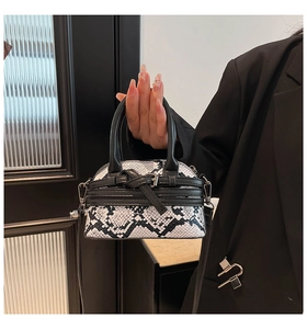 Detailed macro view of the black and white snakeskin pattern on a mini top handle bag